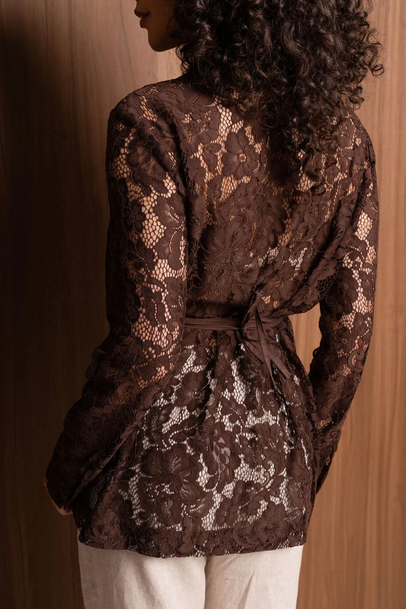 Brown floral lace blouse with tie waist on woman against wooden background
