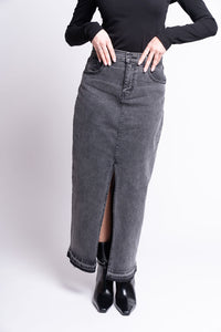Person wearing a black top and gray denim skirt on a white background